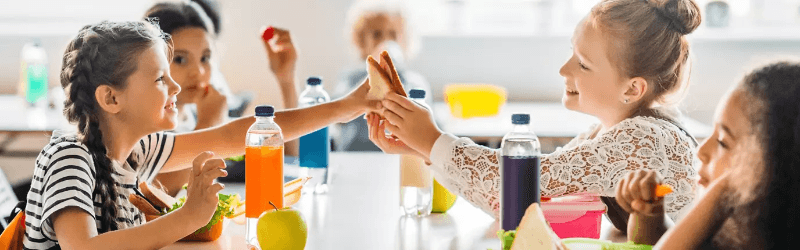 Children sharing lunch at a cafeteria table
